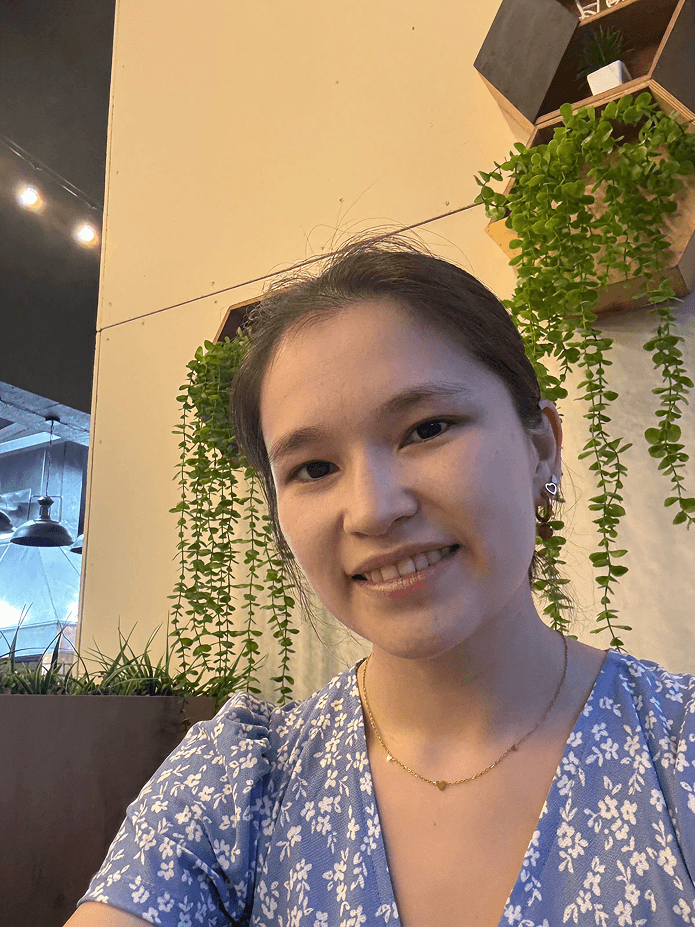 woman in black long sleeve shirt standing near brown wooden shelf