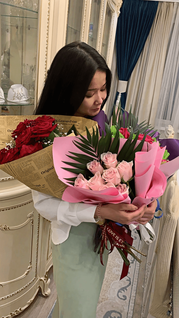 woman in black long sleeve shirt standing near brown wooden shelf